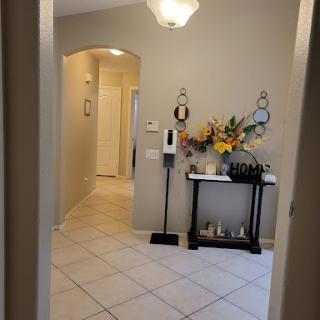 A well-lit entryway featuring decorative flowers and a stylish table.