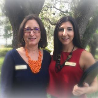 Two women posing together outdoors with name tags.