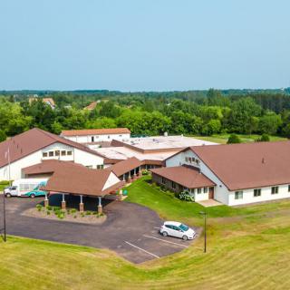 Aerial view of a large building complex in a rural area surrounded by greenery.
