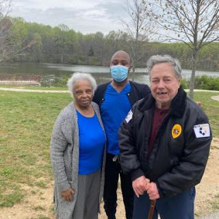A cheerful moment captured in the park, featuring three individuals enjoying a day outdoors.