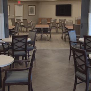 A spacious and modern dining area featuring tables and chairs arranged neatly, providing a welcoming atmosphere.