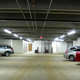 A spacious and well-lit parking garage featuring parked cars.