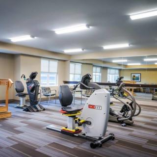 A spacious gym with various exercise equipment including cardio machines.