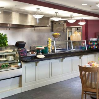 A cozy cafeteria with a food service counter and seating area.