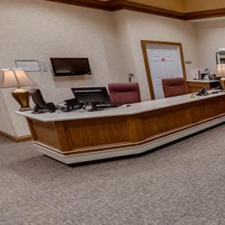 An office reception area featuring a desk with computers and chairs.