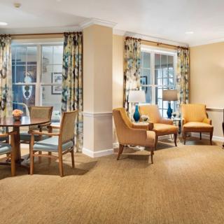 A cozy and elegantly designed living room with chairs, a table, and decorative lamps.