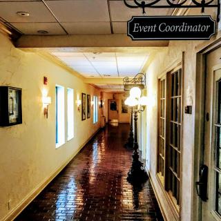 A well-lit hallway with an 'Event Coordinator' sign on the door.