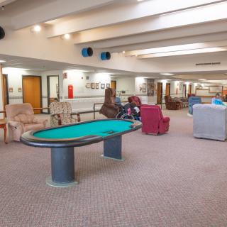 A spacious recreation room featuring a poker table and comfortable seating areas.