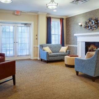 A cozy living room with sofas, a fireplace, and large windows.