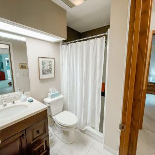 A clean and modern bathroom with a sink, toilet, and shower area.