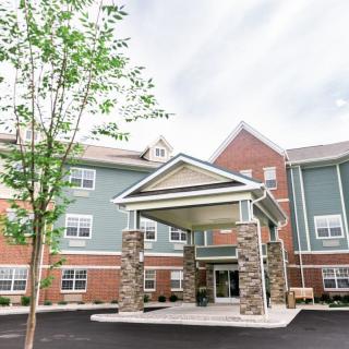 The exterior of a modern multi-story building with a prominent entrance and surrounding trees.