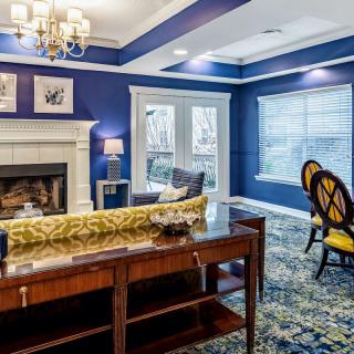A stylish living room with blue walls, featuring a fireplace and elegant furnishings.
