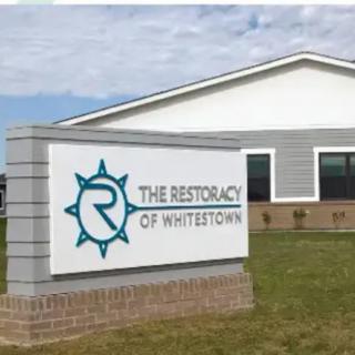 A building exterior with a sign reading 'The Restoracy of Whitestown.'