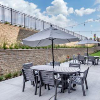 Outdoor patio area with tables and chairs under umbrellas.