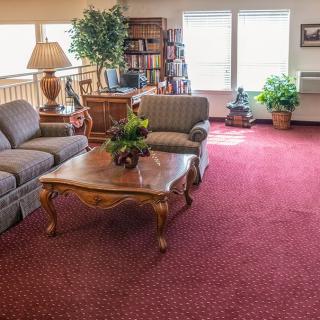 A cozy living room with comfortable seating, a wooden coffee table, and various decorative elements such as plants and a bookshelf.