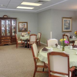 An elegant dining room with neatly arranged tables and chairs, decorated with table settings.