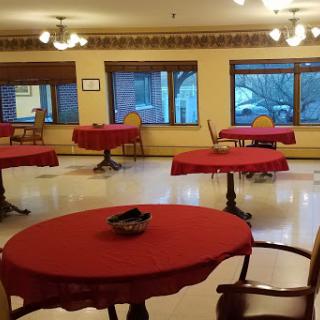 A dining area with red tablecloths and natural light from large windows.