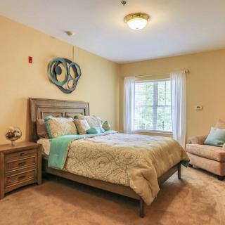 A cozy bedroom with soft lighting, featuring a large bed and warm decor.