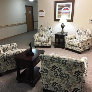 A cozy waiting area with patterned chairs and a small central table under soft lighting.