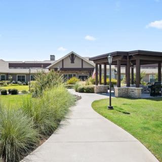 A scenic pathway leading to a building surrounded by well-maintained landscaping and greenery.