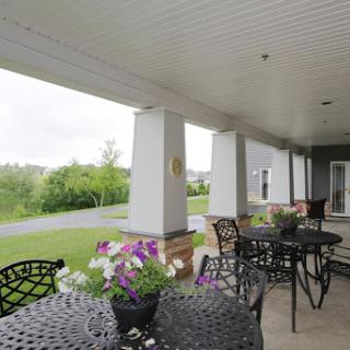 A serene outdoor patio adorned with blooming flowers and elegant furniture, perfect for relaxation amidst nature.
