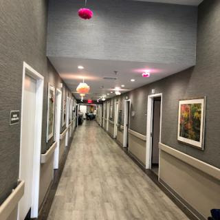 A long, well-lit hallway featuring multiple doors and decorative lighting.