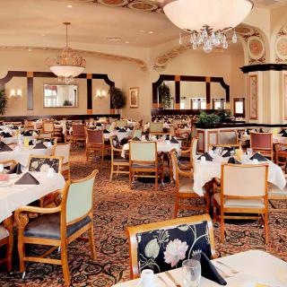 An elegant dining area with well-arranged tables and chandeliers.