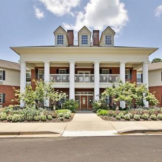 A large colonial-style building with white columns and well-maintained landscaping.