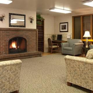 A cozy living room with a warm fireplace and comfortable seating.