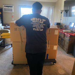 A person moving boxes in a cozy living room.