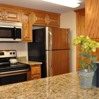 A modern kitchen featuring stainless steel appliances and warm wooden cabinetry.