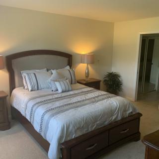 A cozy bedroom with a neatly made bed and warm lighting.