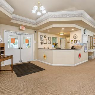 A welcoming reception area with a desk and seating, decorated with framed artwork.