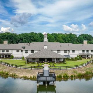 A luxurious estate with a large mansion overlooking a serene lake.