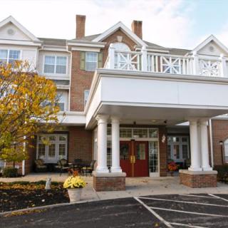 A large building with a prominent entrance featuring columns and a porch.