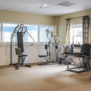A small gym with various exercise machines and equipment.
