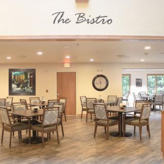 A cozy bistro with neatly arranged tables and chairs, featuring a warm and inviting interior design.