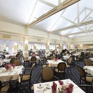 An elegant dining room with neatly arranged tables and chairs, ready for guests.