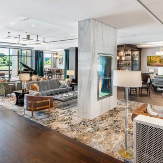A spacious and elegantly designed living area featuring modern furnishings, a grand piano, and stylish decor.