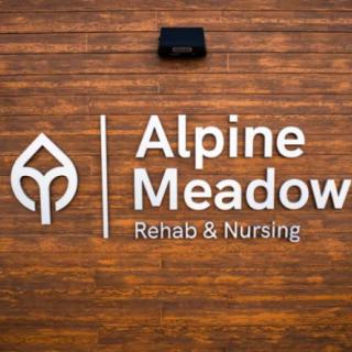 Sign for Alpine Meadow Rehab & Nursing facility on a wooden background.