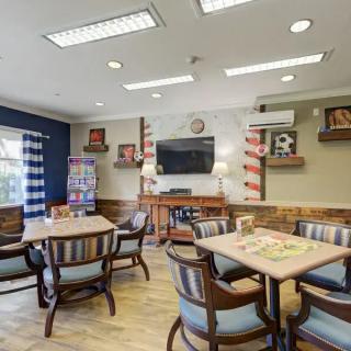 A cozy and well-decorated indoor social area with tables, chairs, and a television.