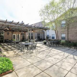 A sunny courtyard with outdoor seating and a pergola.