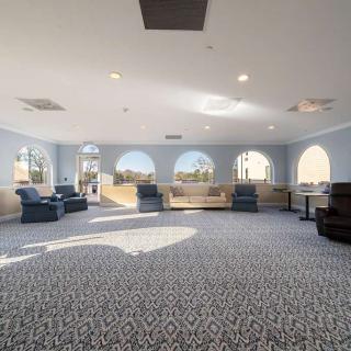 A spacious lounge area with comfortable seating and large windows.