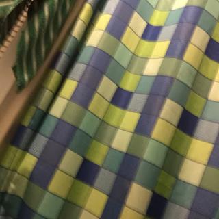 A vibrant curtain featuring a geometric pattern of blue and green squares.
