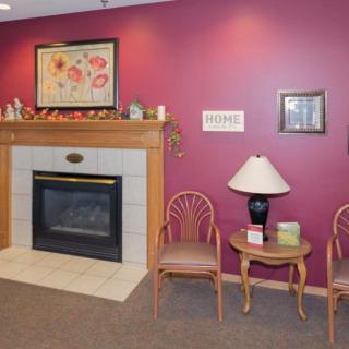 A cozy interior with a fireplace, artwork, and seating area.