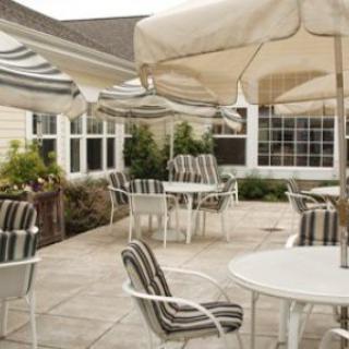 Charming patio area with striped cushioned chairs and umbrellas for shade.