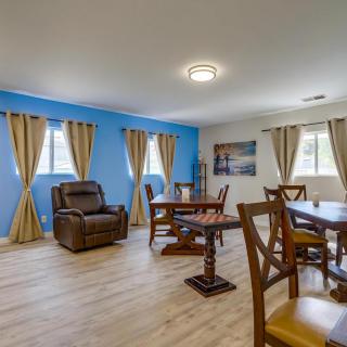 A spacious living and dining area with a blue accent wall, comfortable seating, and warm wooden flooring.
