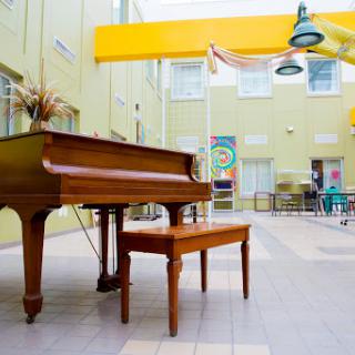 A grand piano positioned in a bright and spacious interior, inviting musical creativity.
