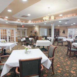 A spacious dining room with neatly arranged tables and chairs, featuring elegant decor.