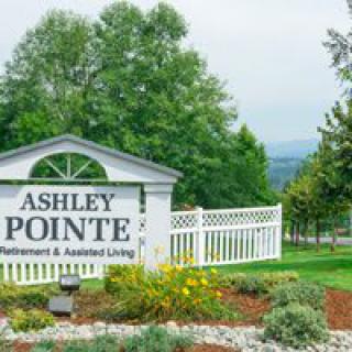 Entrance sign for Ashley Pointe Retirement & Assisted Living surrounded by greenery.